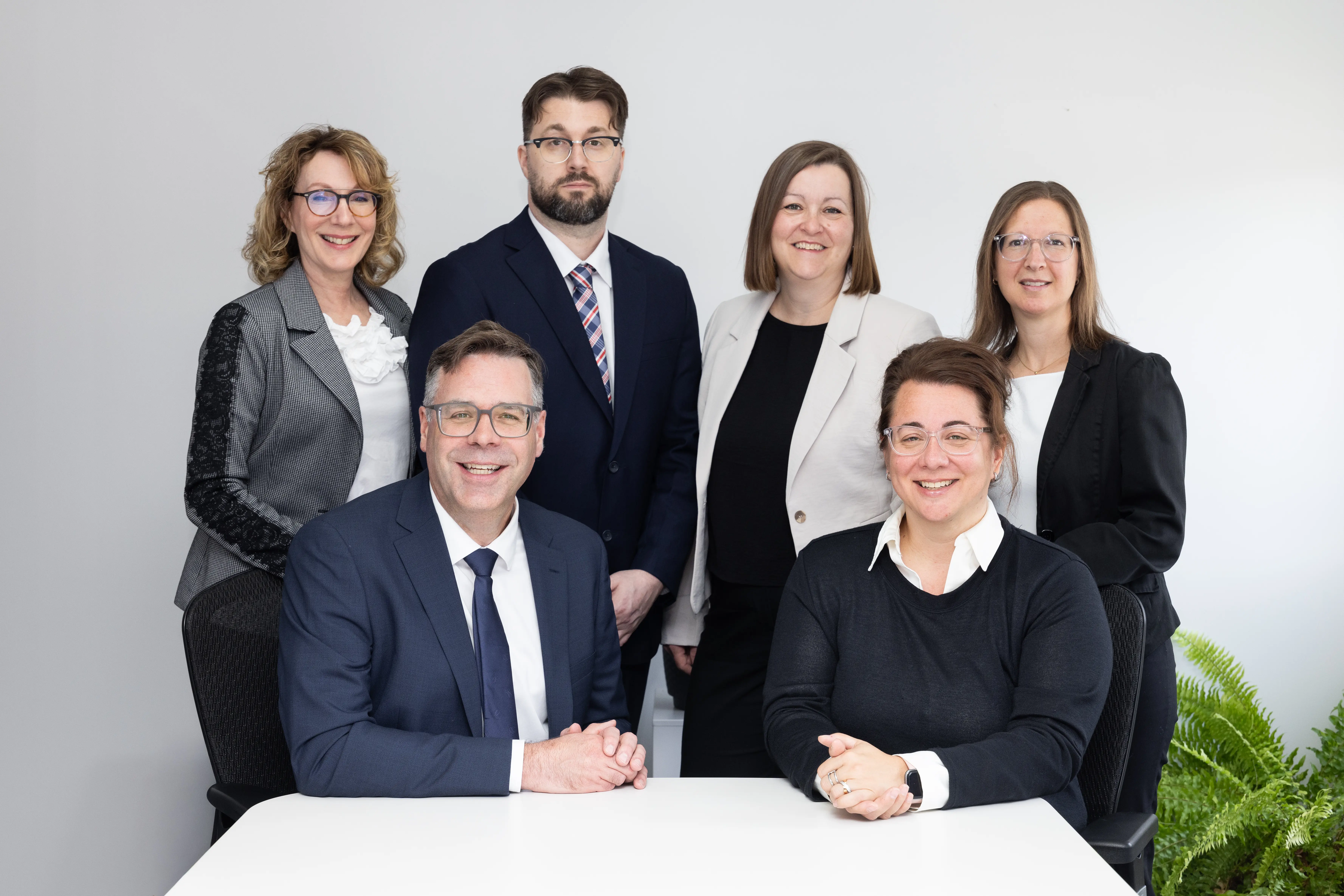 Photo de groupe de l’équipe de DNA Notaires d’affaires réunie autour d’une table au bureau