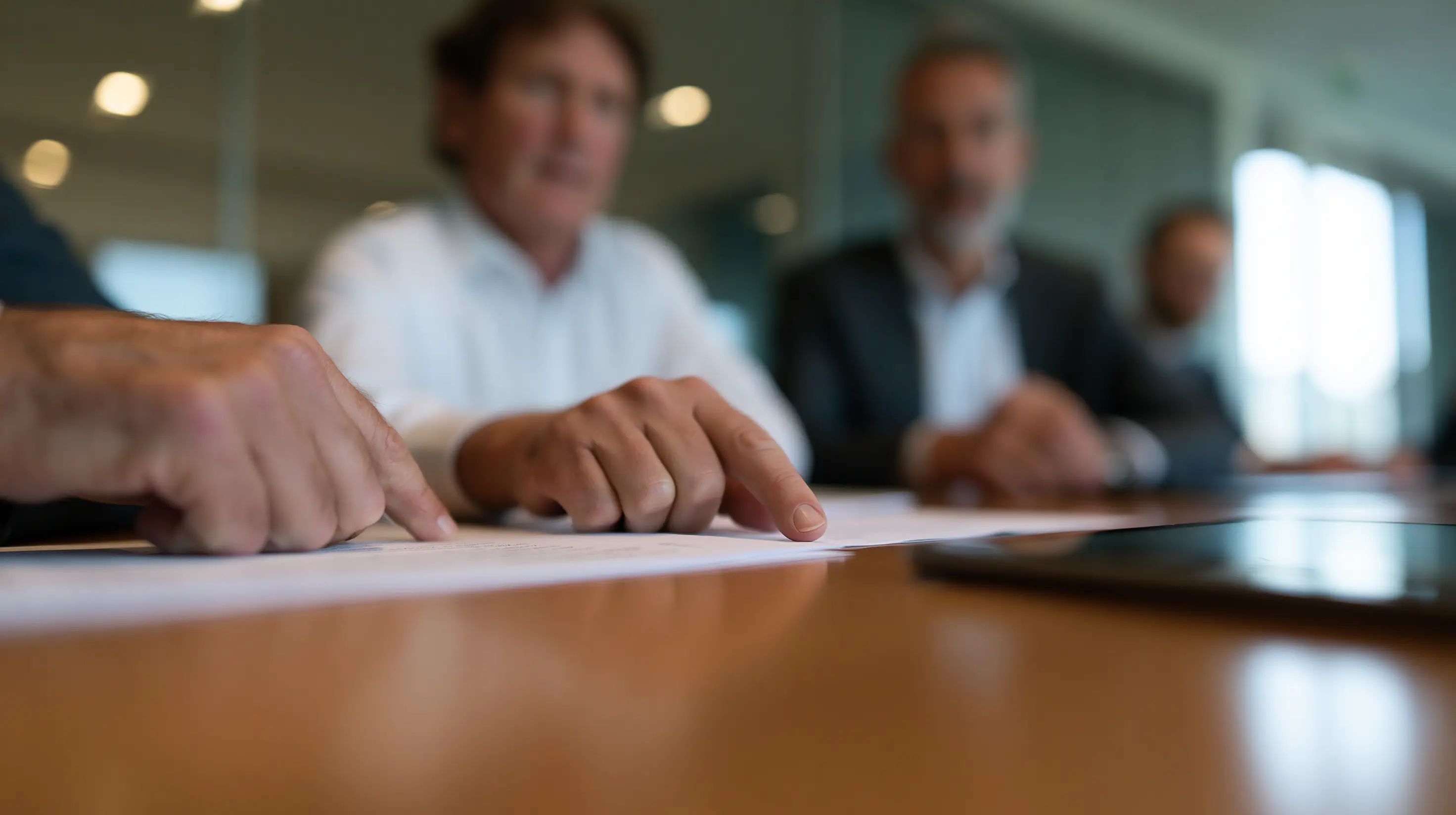 Dirigeants d’entreprise examinant un contrat autour d’une table de réunion